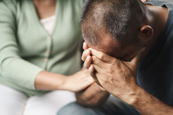 Female Psychologist, friend or family sitting and put hands on the shoulder for cheer up to mental depress man