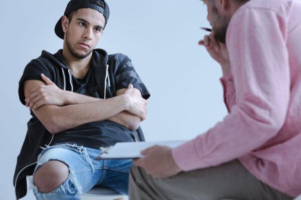 A withdrawn rebel young boy with behavioral and social disorders during his individual meeting with a psychotherapist